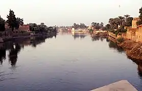 Vista del canal de Bahr Yussef en las cercanías de la ciudad de Menia, Egipto. A ambos lados del mismo se sitúan viviendas, campos de cultivo y árboles, sustentados gracias al agua.