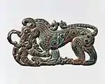 Hebilla de cinturón con forma de lobo en pie, característica de los artefactos nómadas del sur de Ningxia y sudeste de Gansú y relacionado con los estilos escitas de la cultura Pazyryk. s. IV AEC.