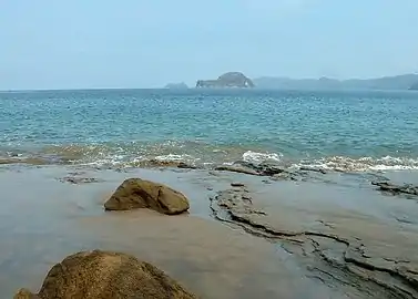 Refugio de Vida Silvestre Bahía JunquillalEste sitio cuenta con 7 diferentes ecosistemas costeros y una extensión de 505 ha. La playa de Bahía Junquillal, de 2 km de largo, tranquila y de gran belleza escénica, posee la Bandera Azul Ecológica. En la bahía se encuentra la Isla Muñecos (en la foto), donde se encuentra una importante formación de coral. El refugio posee tres senderos, uno de los cuales posee una laguna, y es posible observar aves y pequeños mamíferos.