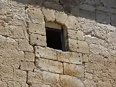Ventana del siglo XV donde se ven los agujeros de la reja arrancada