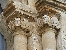 Capitel con cabezas humanas entre hojarasca