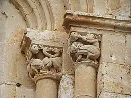 Capitel con pareja de sirenas con cuerpo de ave, con un gorro medieval y soplando un cuerno
