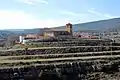 Vista general (septentrional) de la parroquial de Alobras (Teruel), situada sobre un cerrito alomado, con detalle del abancalamiento (2017).