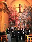 Vista frontal del antiguo retablo de pincel, obra de Salomón (1976) en la parroquial de Casas Bajas (Valencia), con detalle del Coro Interparroquial.