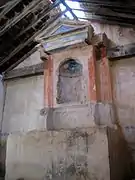 Vista del interior de la ermita de San Pedro en El Cuervo (Teruel), con detalle del presbiterio, altar y retablo.