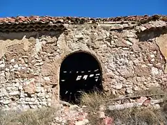 Vista de la fachada principal de la ermita de San Pedro en El Cuervo (Teruel), con detalle del arco de la entrada.