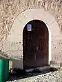 Vista de la entrada a la iglesia de Santa María en Moya (Cuenca), lado de la epístola, con detalle del arco adovelado de medio punto. Siglo XIV.