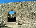 Vista exterior de la Puerta de los Ojos en Moya (Cuenca), con detalle de una tronera de tipo "palo y orbe" restaurada. Siglo XV.