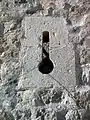 Detalle de tronera tipo "palo y orbe" restaurada en la Puerta de los Ojos en Moya (Cuenca). Siglo XV.