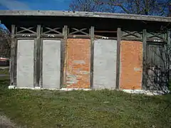 Edificio de servicios con las placas cerámicas de entrada muy deterioradas