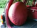 Rueda de repuesto de tamaño completo, con cubierta, montada en el espacio de carga de un Jeep Grand Cherokee de 1993