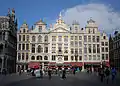 Casas en los números 20 a 28 de la Grand-Place: Le Cerf (el ciervo), Joseph;  Anne; L’Ange (el ángel); La Chaloupe d’Or (la chalupa de oro);  Le Pigeon (la paloma);  Le Marchand d’Or (el comerciante de oro).