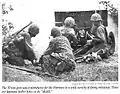 Artilleros de un M3 37 mm en acción, Saipán, 1944. De izquierda a derecha hay dos abastecedores de municiones, el artillero y el artillero auxiliar. Obsérvese el escudo desplegado.