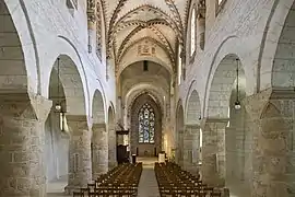 Interior de la iglesia abacial de Romainmotier, mostrando los masivo pilares románicos y los arcos de las bóvedas de arista