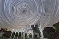 Senda estelar apuntando hacia Polaris sobre las ruinas de una abadía en el condado de Louth, Irlanda.