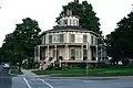 Casa grande con estructura de madera, techo inclinado y linterna. Las ventanas arqueadas y las contraventanas se suman al efecto decorativo. La Casa Octagon Rich-Twinn en Akron, Nueva York.