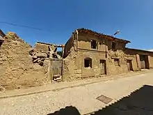 Vista de casa de adobe con arco de sillería en Amayuelas de Arriba.