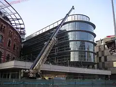 El nuevo anexo en vidrio del futuro centro comercial cubriendo la Casa Fajol