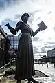 Estatua de Annie Kenney en Oldham con "Votos para mujeres"