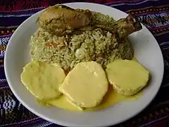 Arroz verde con pollo, acompañado de papa a la huancaína (Perú)