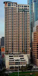 Elevated view of The Ashton from south in the Hyatt Regency Hotel. The tower has a white base, while the tower is brick/crimson red color.