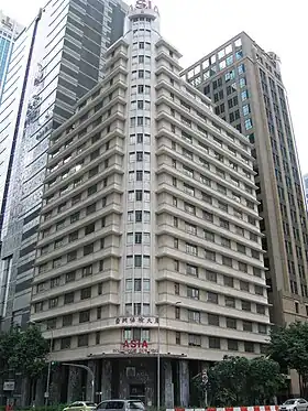  Beige rectangular building, 20 storeys and at 87 metres tall, with newer taller skyscrapers seen in the background.