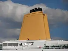 Los gases de escape del motor se expulsan a través de uno de los tubos de escape colocados en un embudo de un crucero moderno.