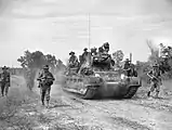 Las tropas australianas del 2/43.° Batallón avanzan con un tanque Matilda en Maeda-shima en una misión de barrido para despejar el área de tropas japonesas, 12 de junio de 1945.