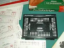 Autobridge. El mejor medio de aprender a cartear solo. Muy utilizado antes de los medios electrónicos. Las manos en papel se introducen bajo el teclado que el jugador debe ir corriendo una a una. Si aparece el n.º de la baza en juego, la jugada es correcta.