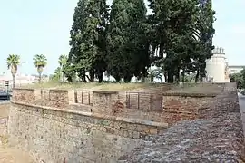 Lienzo al oeste con troneras defendiendo el foso y Puerta de Palmas al fondo