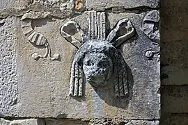 Máscara de teatro reutilizada en el exterior de la basílica de Saint-Just en Valcabrère.