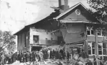 los curiosos se arremolinan mirando el edificio semidestruido de la Escuela de Bath