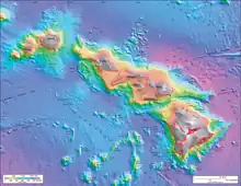 Representación batimétrica de la cadena de islas hawaianas mostrando profundidades mayores como azul, profundidades menores como rojo, y la tierra expuesta en gris. La isla principal es la más alta, las que se encuentran en el centro están en una meseta elevada, y otras tres islas están más alejadas en el extremo oeste de la cadena. Una serie de pequeñas protuberancias (montañas submarinas) se encuentran al sur de la masa de tierra principal.