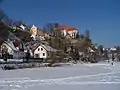 Monasterio y casas al lado del río en invierno