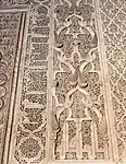 Motivos arabescos y de piñas junto con inscripciones cúficas alrededor del mihrab de la madrasa Ben Youssef, en Marrakech