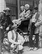 Reparto de The Big Valley. Izq. a der.: Richard Long, Linda Evans, Barbara Stanwyck, Peter Breck y Lee Majors en la rueda de la carreta