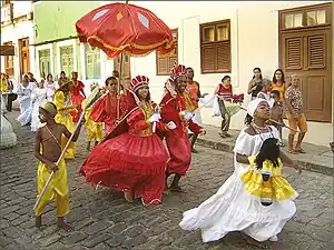 Procesión de Maracatu en Olinda. La dama del palacio (hasta adelante) porta una calunga, que representa a una entidade espiritual.