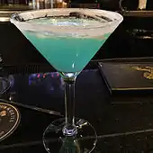 Un Lemon Drop de mora azul servido con un vaso con borde de azúcar.