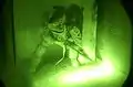 Una brecha balística en la noche de una puerta cerrada con candado; esta escopeta tiene una empuñadura de pistola en lugar de una culata completa para que sea más compacta