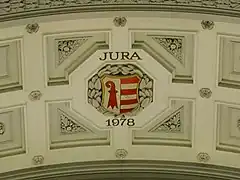 Escudo de Armas del Jura en un arco.