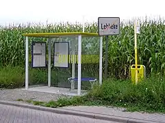 Esta parada en Bélgica cuenta con marquesina con techo, bancos, recorridos y horarios de las líneas de autobús y tacho de basura.