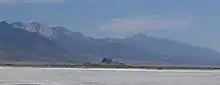 Flat expanse with a mountain range in the distance.