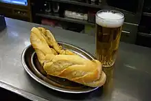 Bocadillo español, relleno de calamares acompañado de una cerveza