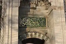 Una inscripción caligráfica encima de una puerta de la mezquita