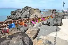 Las cadenas del paseo marítimo de Playa Blanca, en el Municipio de Yaiza, Lanzarote, están llenas de los conocidos candados del amor. Actualmente no revisten peligro para el ecosistema del lugar, por tratarse de una cadena que sirve de pasarela en el paseo marítimo.