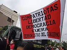 Cartel durante unas protestas contra el gobierno de Pedro Castillo el 28 de julio de 2022. El cartel dice: "Compatriotas, libertad democracia. Fuera: Terroristas del Gobierno".