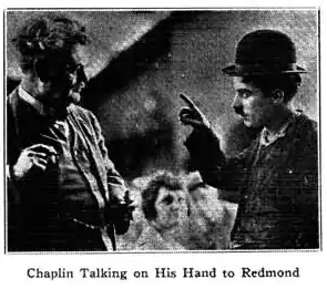 caption = "Chaplin hablando con su mano a Redmond"