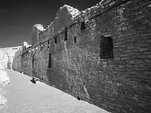 A black-and-white picture of a long brick wall