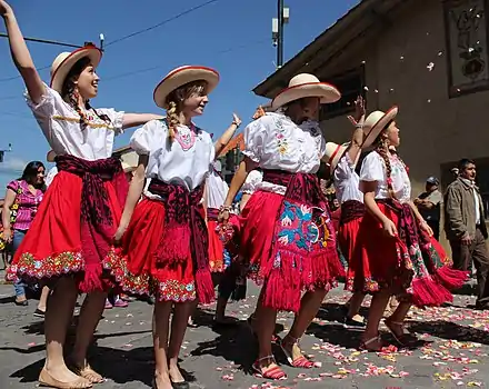 Jóvenes con el traje de chola cuencana durante el Pase del Niño Viajero 2013 en Cuenca (Ecuador).