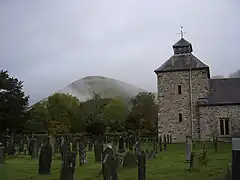 Campanario de Pennant Melangell con un mamelón de fondo.